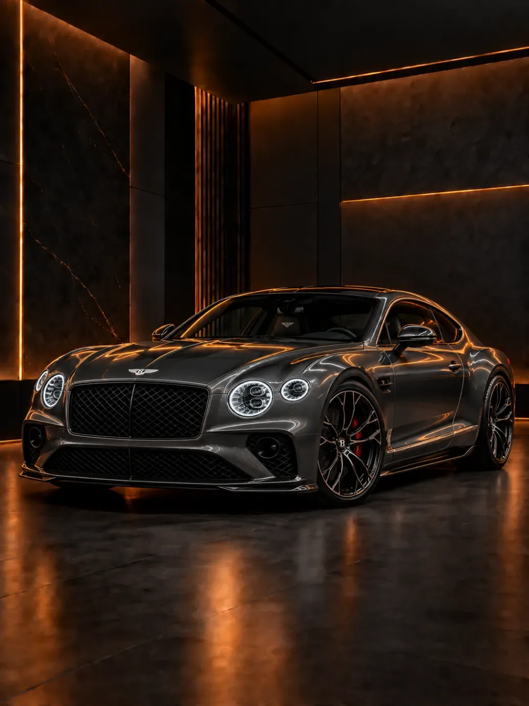 Grey Bentley Continental GT coupe with round LED headlights in a dark studio
