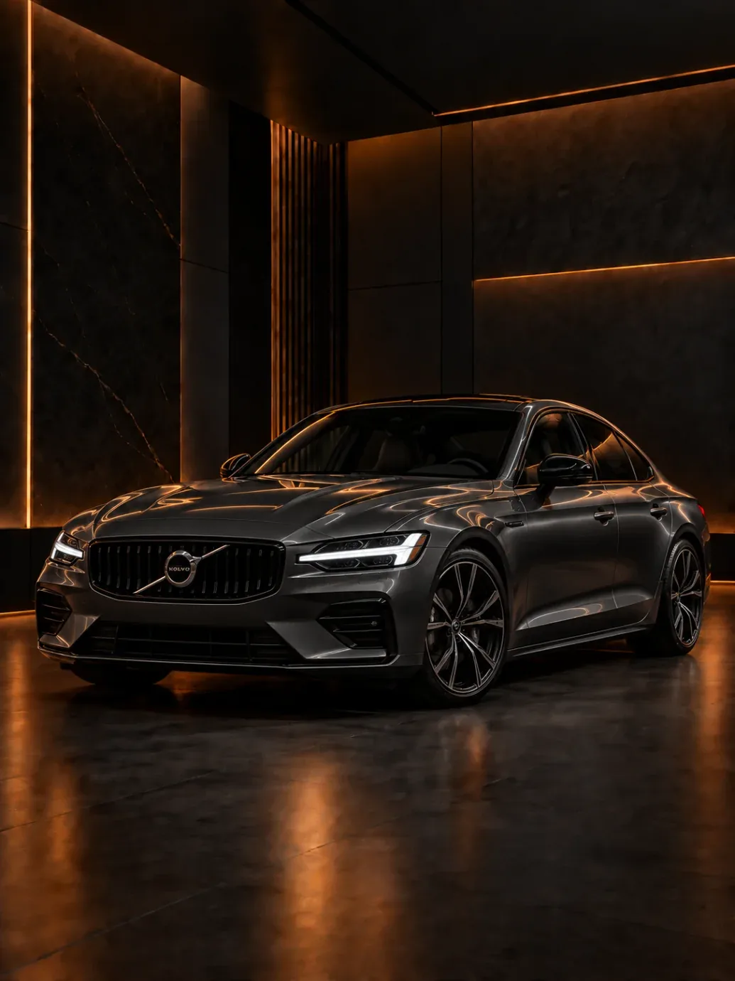 Dark grey Volvo sedan with diagonal grille badge in a dark studio